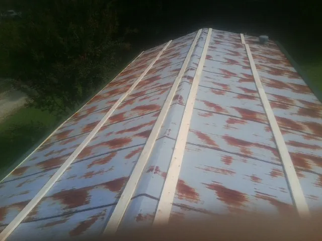 Rusted metal roof panels with new wood purlins before replacement — Storm Damage Roof Repair in Votaw by Roofing Brothers