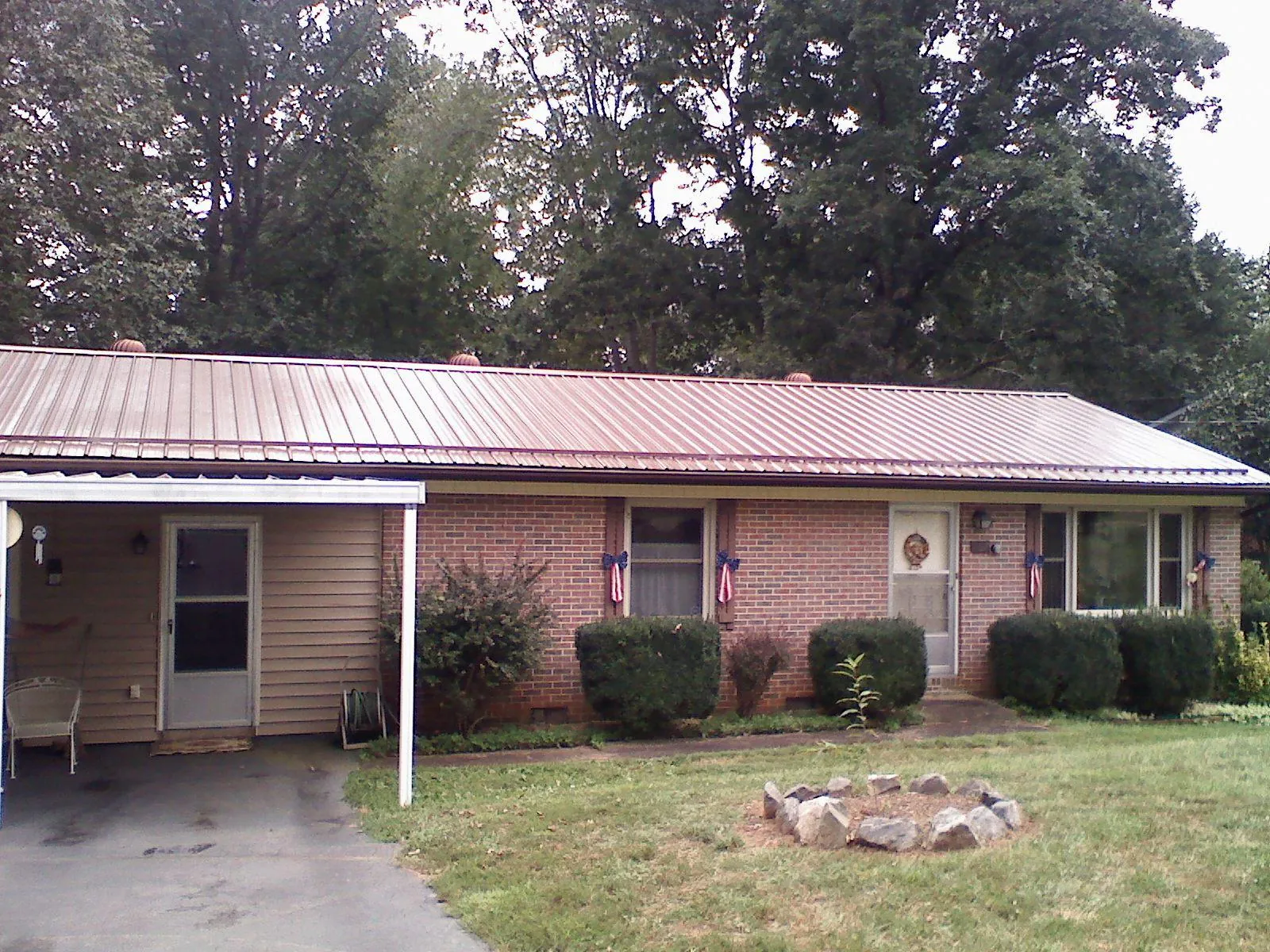 Bronze metal roof and carport on a brick ranch home — Roof Repair work by our crew in Votaw